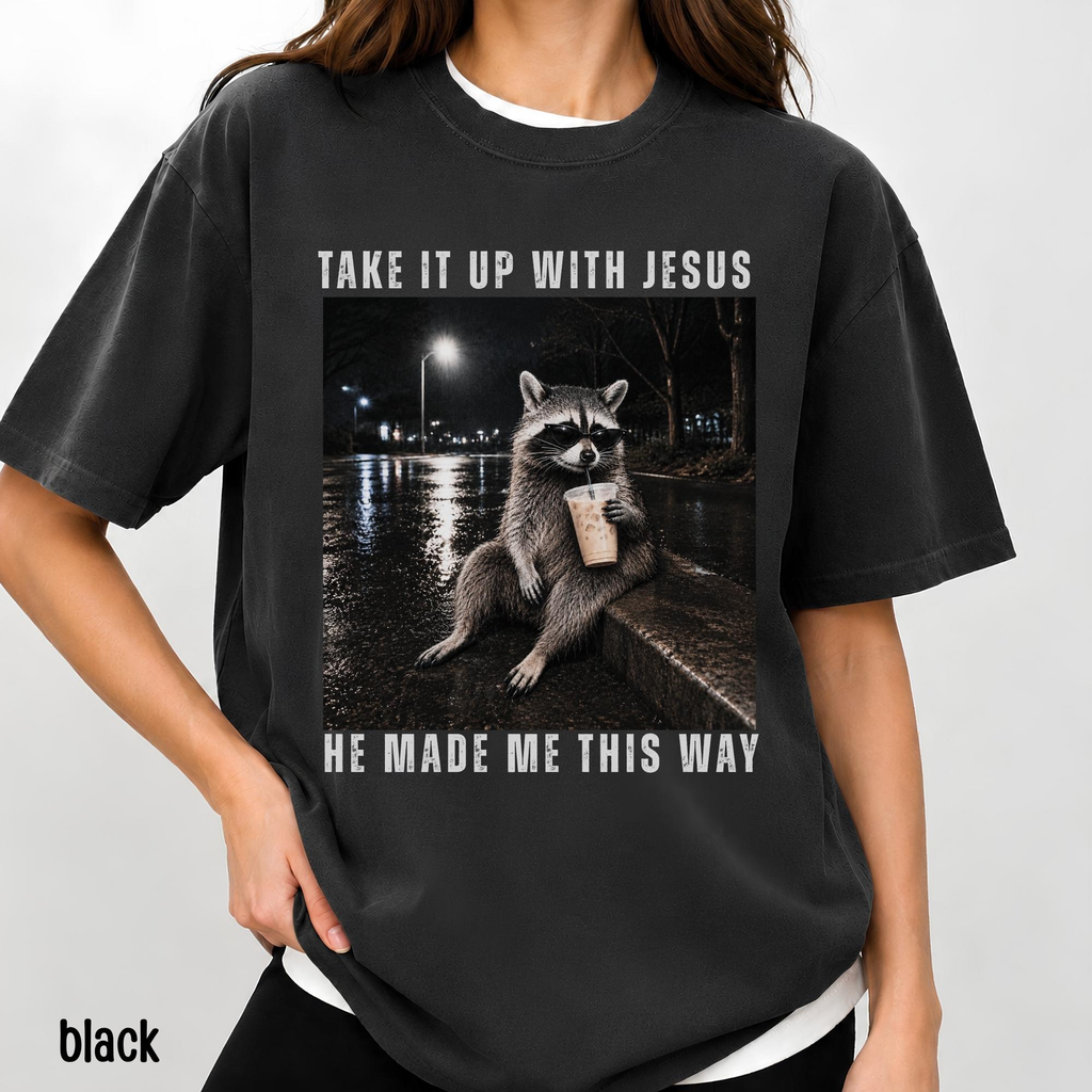 Take It Up With Jesus He Made Me This Way shirt, grunge raccoon in sunglasses sipping iced coffee on a rainy street