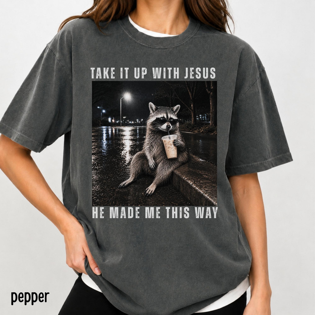 Take It Up With Jesus He Made Me This Way shirt, grunge raccoon in sunglasses sipping iced coffee on a rainy street